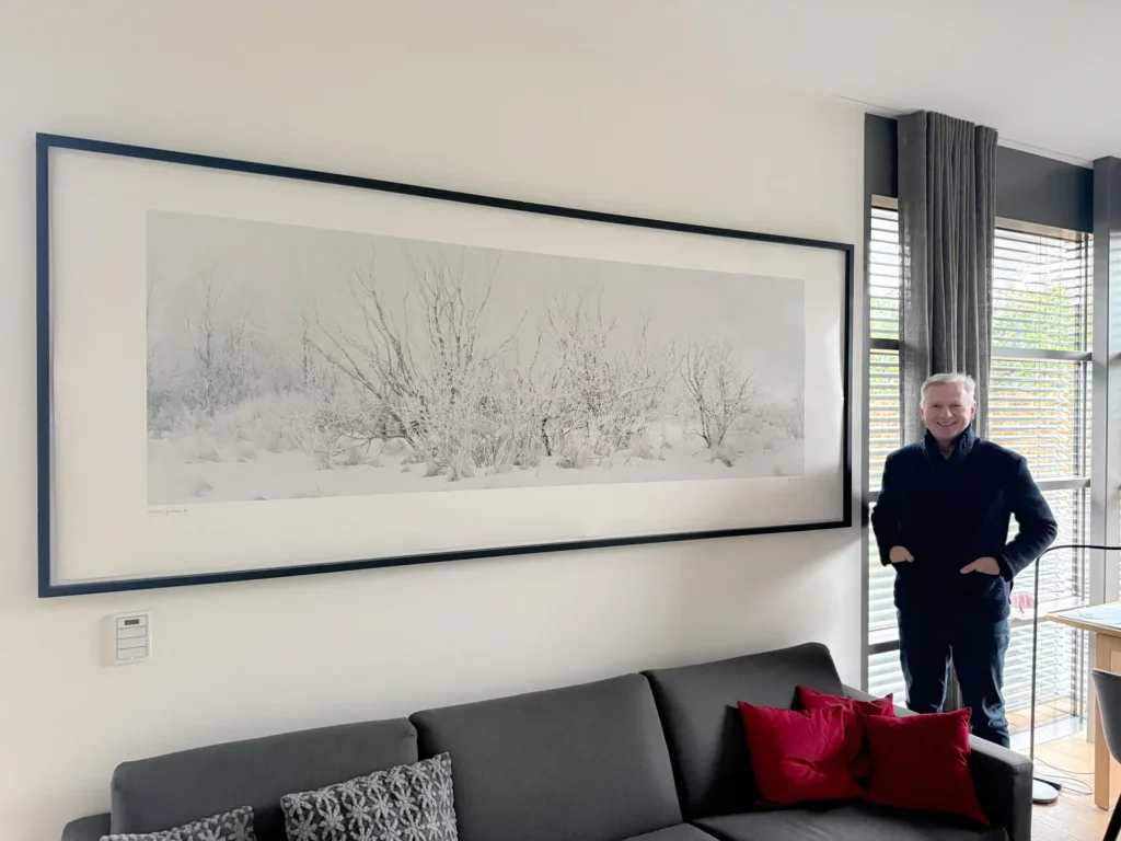Matthias Koch neben dem Panoramabild „Eisbüsche“ in seinem Home-Office